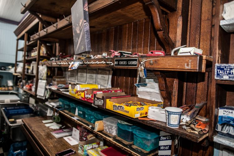 A display of candy and snacks on the wooden shelves.